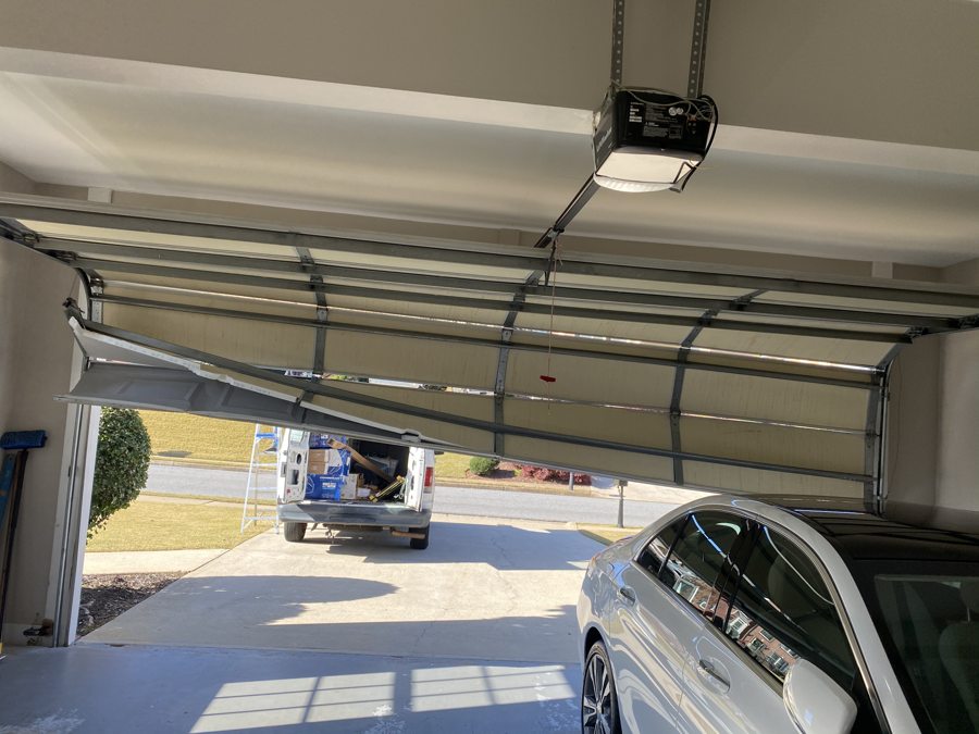 Damaged off-track garage door before replacement in Peachtree Corners, GA