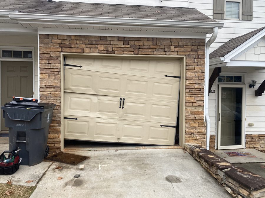 Dented and damaged garage door before replacement in Suwanee, GA