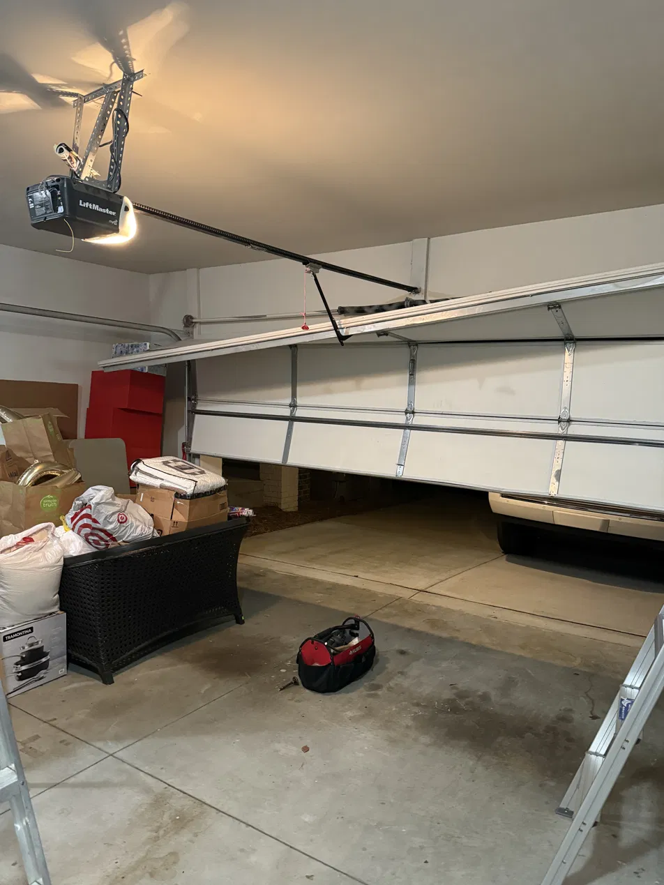 Garage door off its track and resting on a car in a Buckhead Atlanta garage